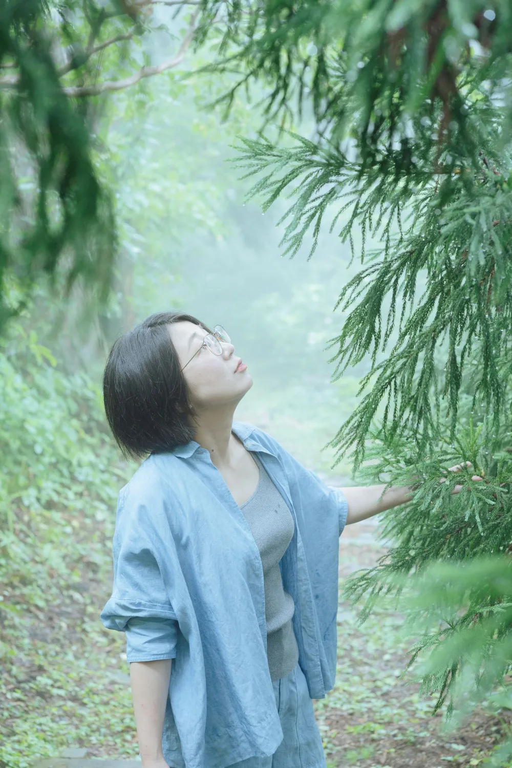 木漏れ日の中で目を閉じる女性のポートレート